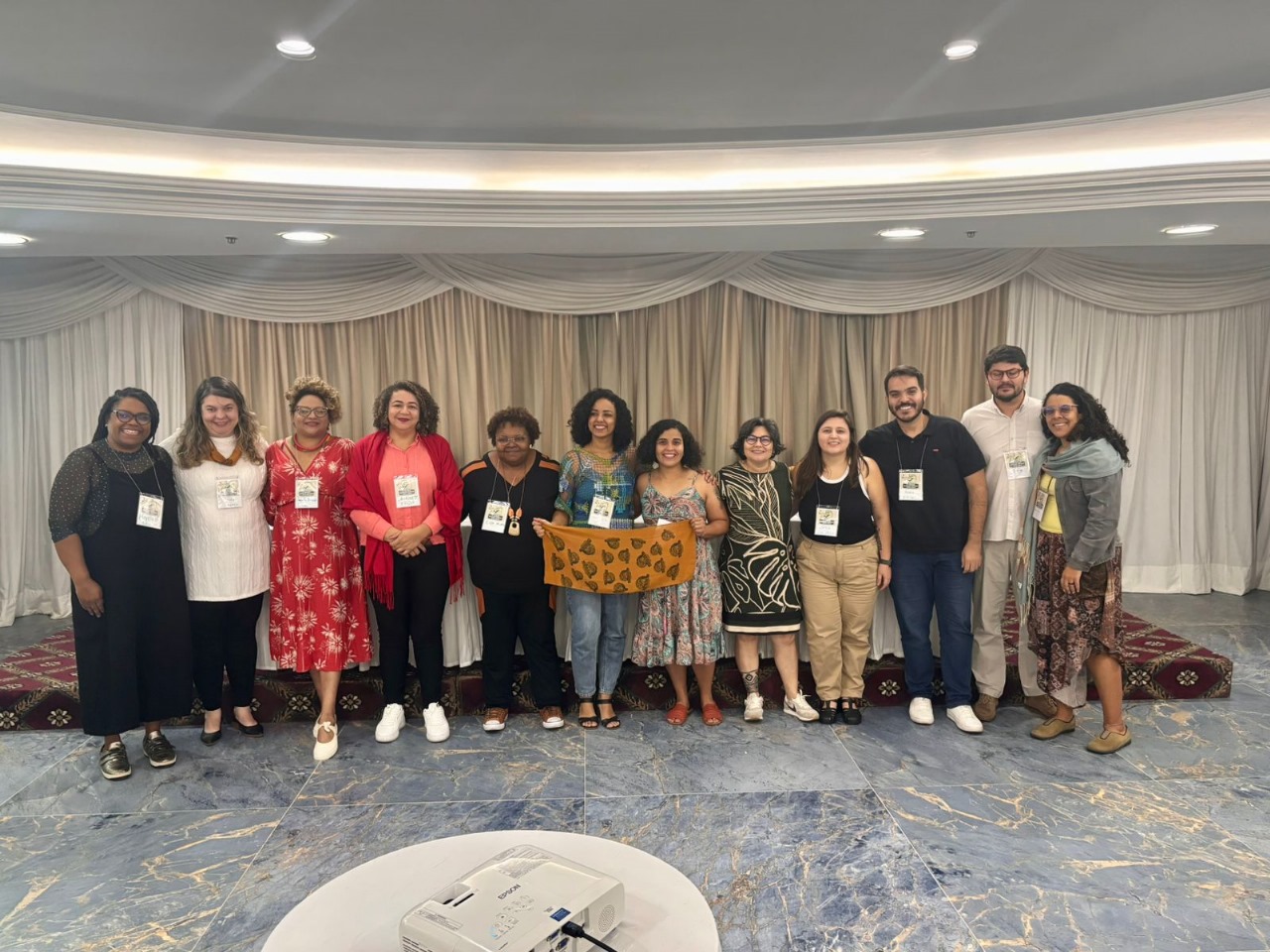 Doze pessoas reunidas, ao final da reunião