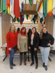 Fotografia com quatro mulheres, lado a lado, brancas e vestindo roupas de frio.