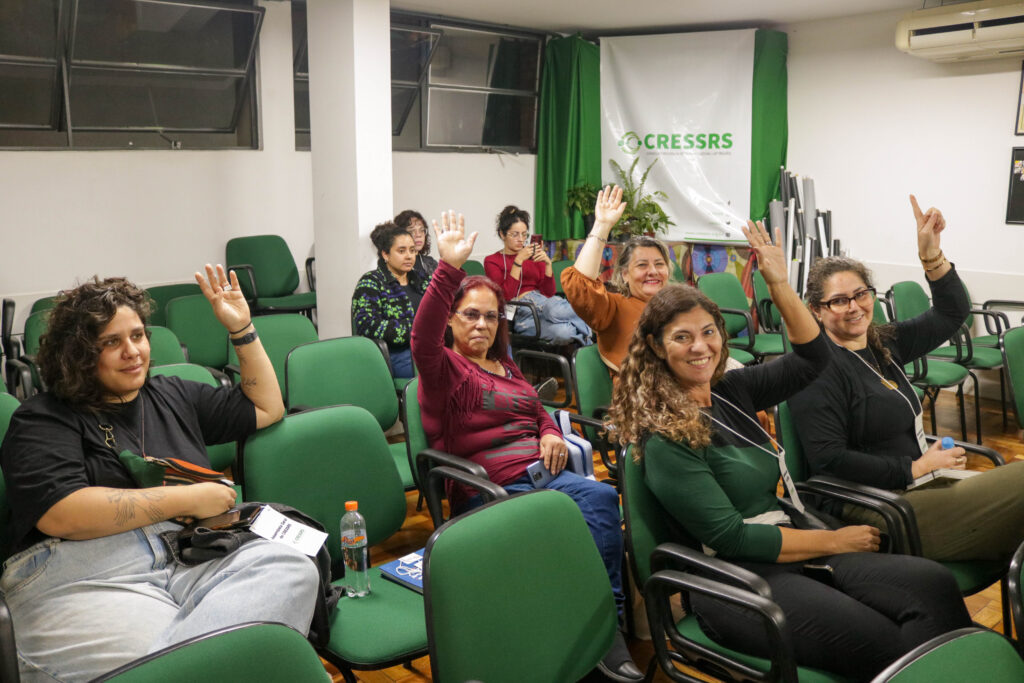 Cinco colegas eleitas para a comissão eleitoral levantam seus crachás. 