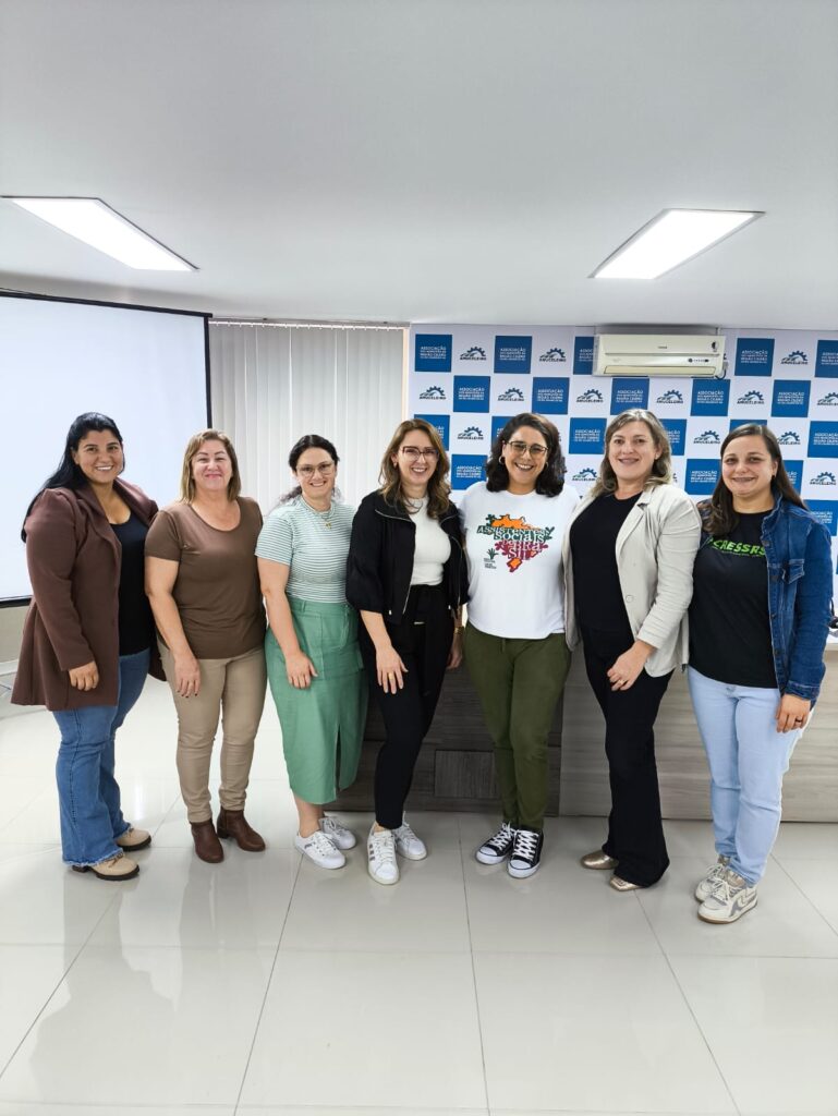Sete mulheres, assistentes sociais, reunidas no minicurso no auditório.