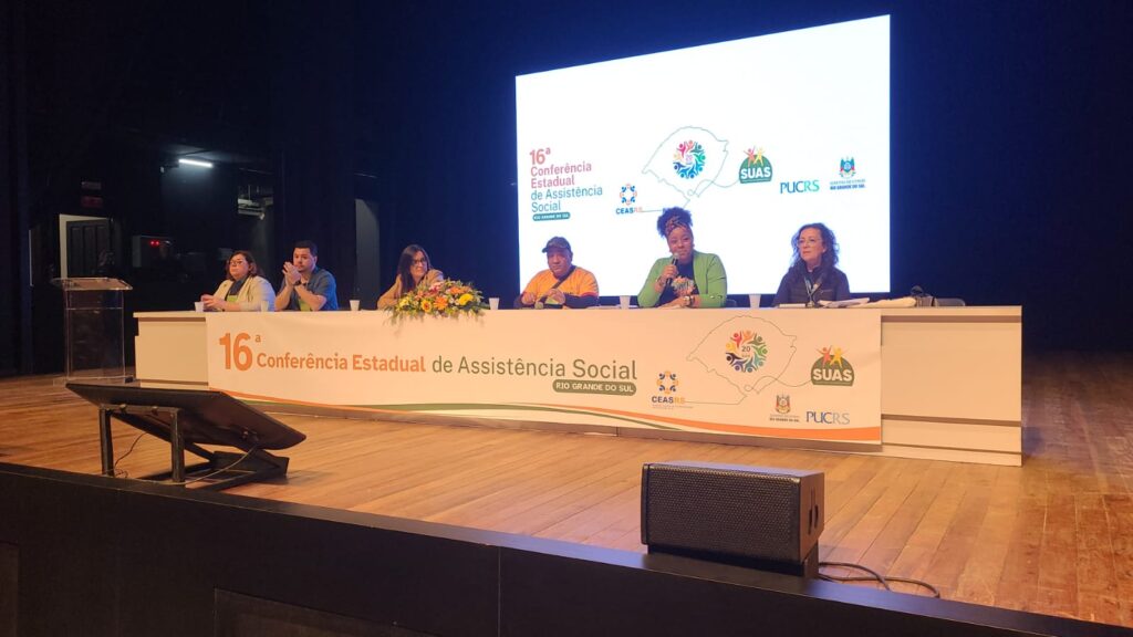 Mesa com cinco mulheres, sendo uma delas a vice-presidenta do CRESSRS, mulher, negra, assistente social. 