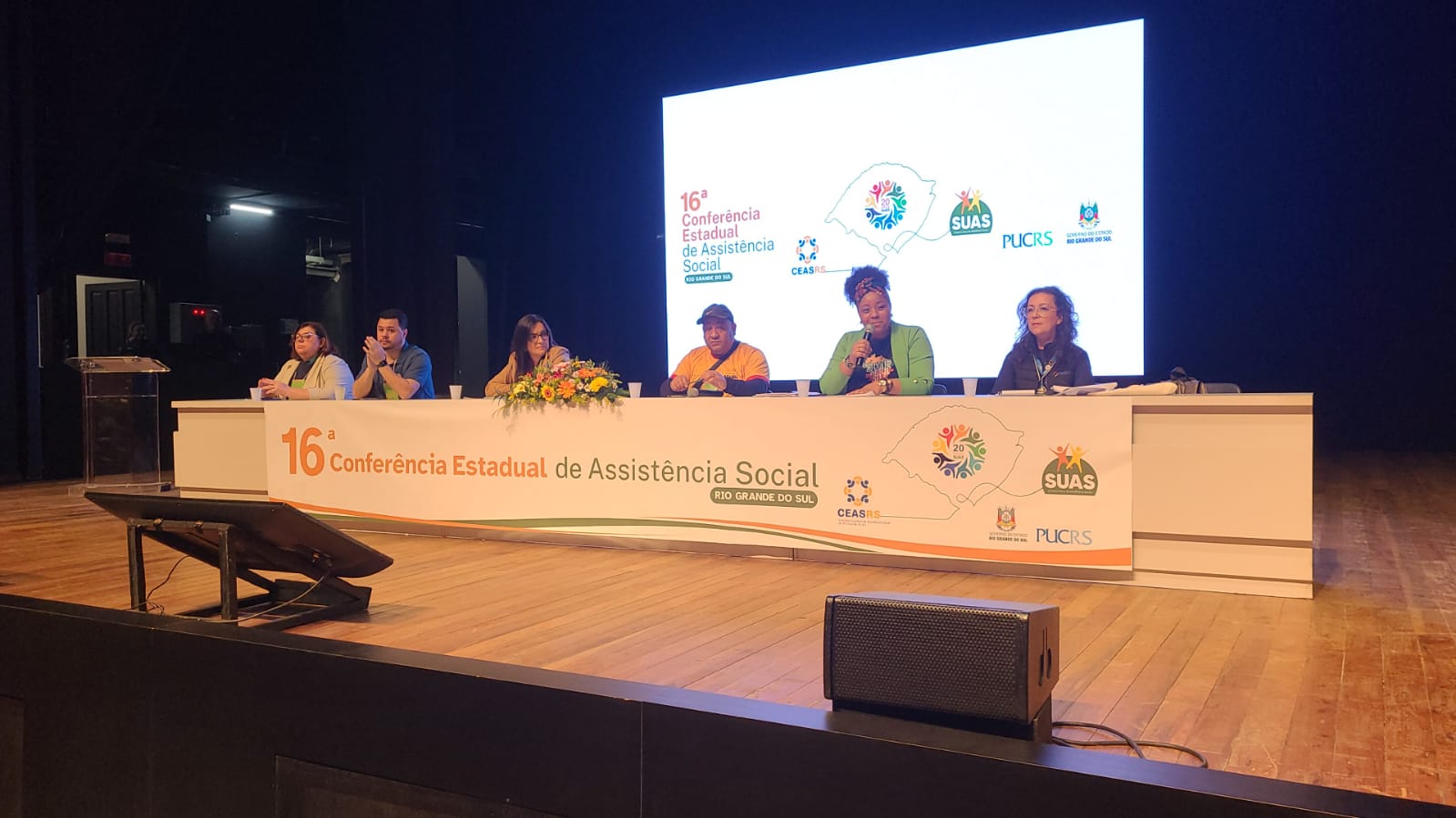 Mesa com cinco mulheres, sendo uma delas a vice-presidenta do CRESSRS, mulher, negra, assistente social.