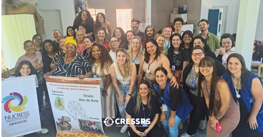 36 pessoas, entre mulheres, homens, brancos, negros, reunidos com os banners do NUCRESS Gravataí e do Quilombo Manoel Barbosa. 