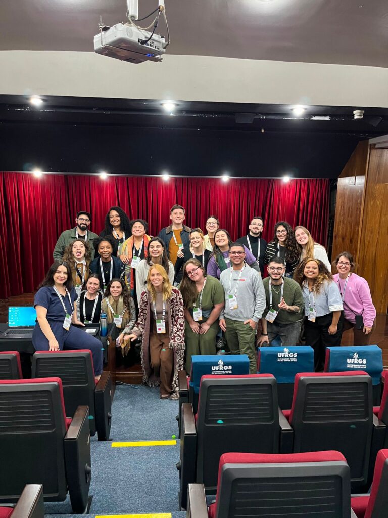 Fotografia com 17 mulheres e cinco homens, em auditório na UFRGS.